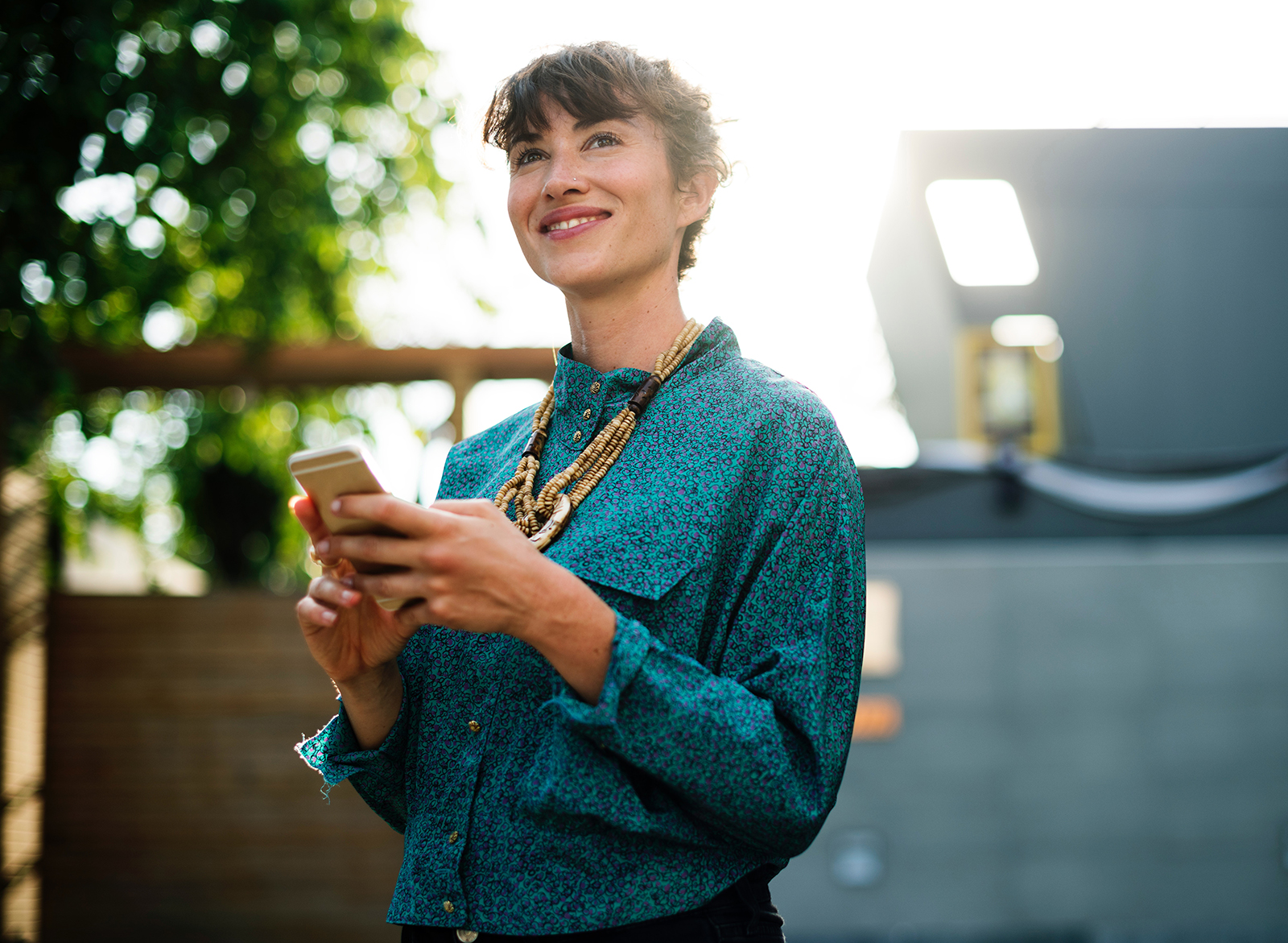 Lady smiling while holding a smart phone, embracing a digital product