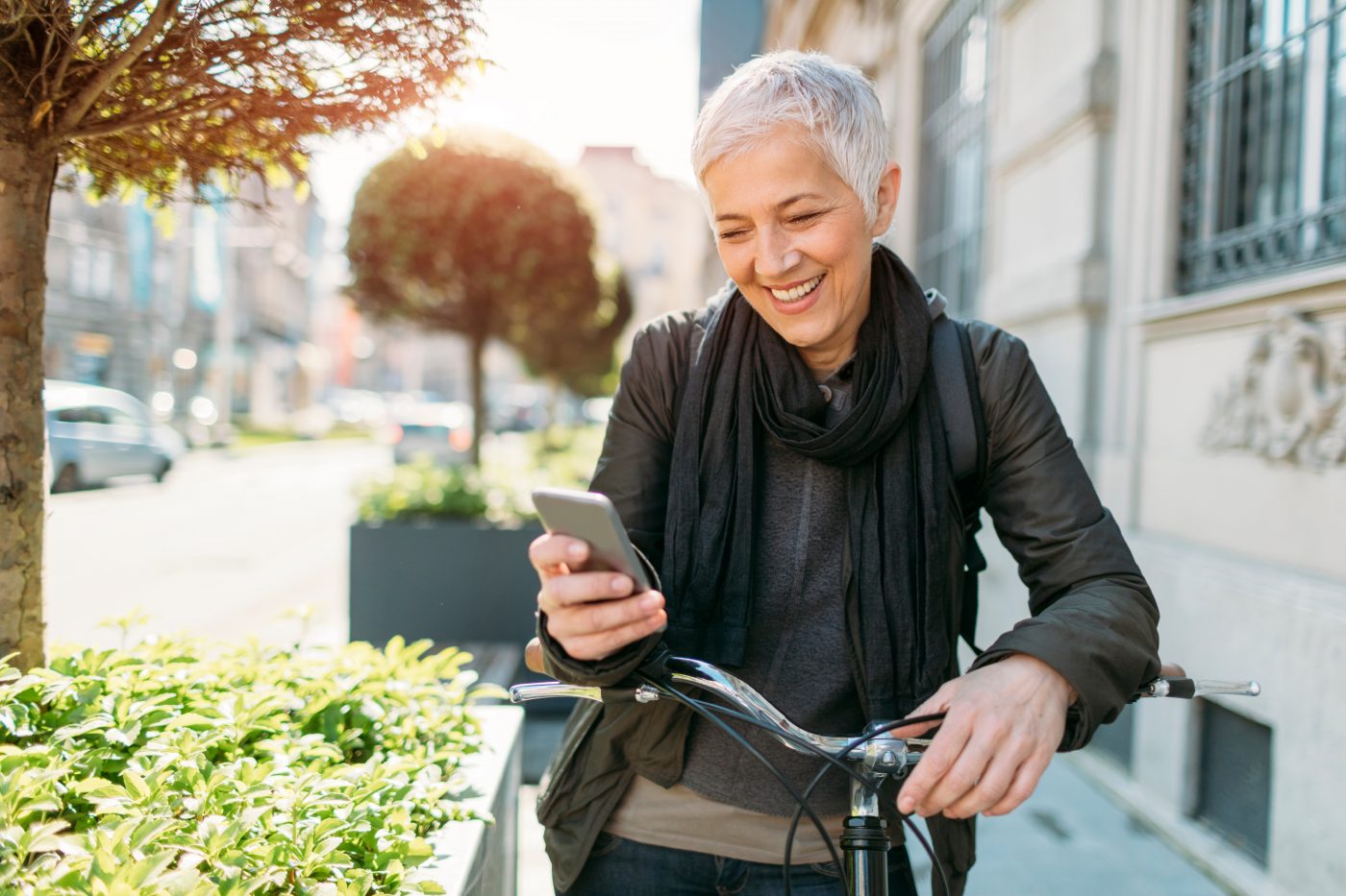 Mature women using her phone on a bicycle