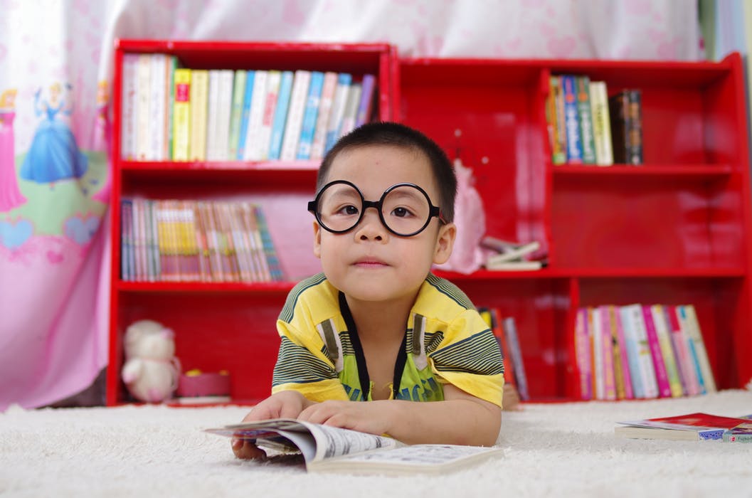 cute child with glasses reading