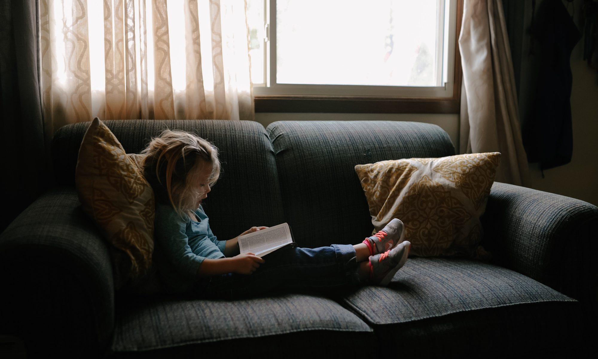 child sitting on the couch reading