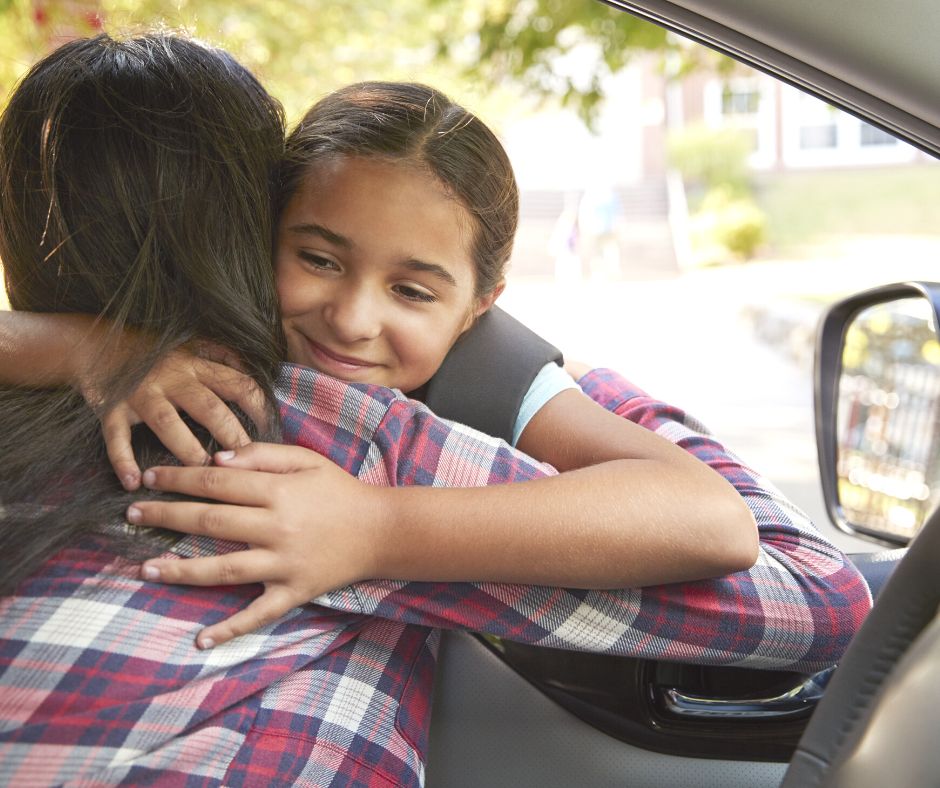a child hugging her parent through a car window