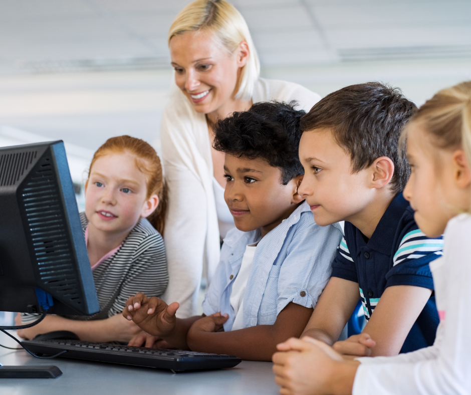 Teacher and kids on computer in class