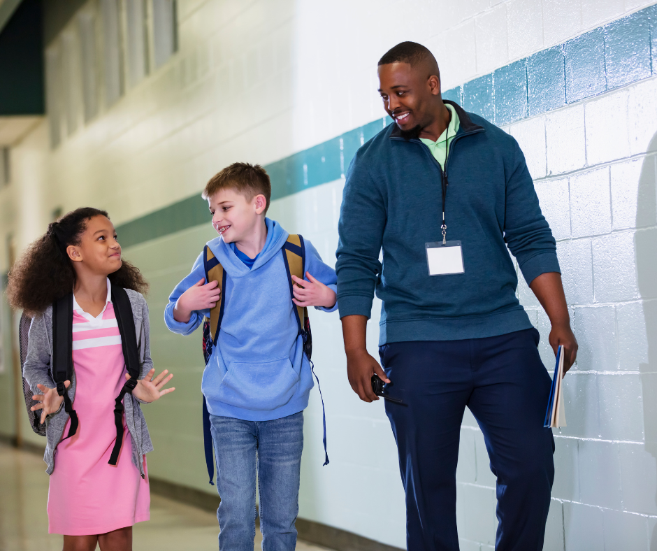Teacher walking with two students in school